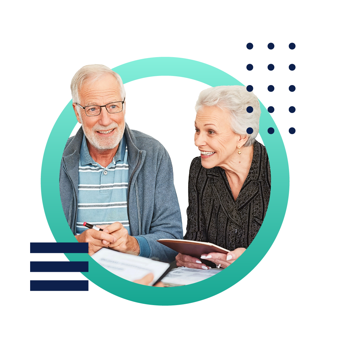 A senior couple smiling and meeting with an insurance agent sitting at a desk.