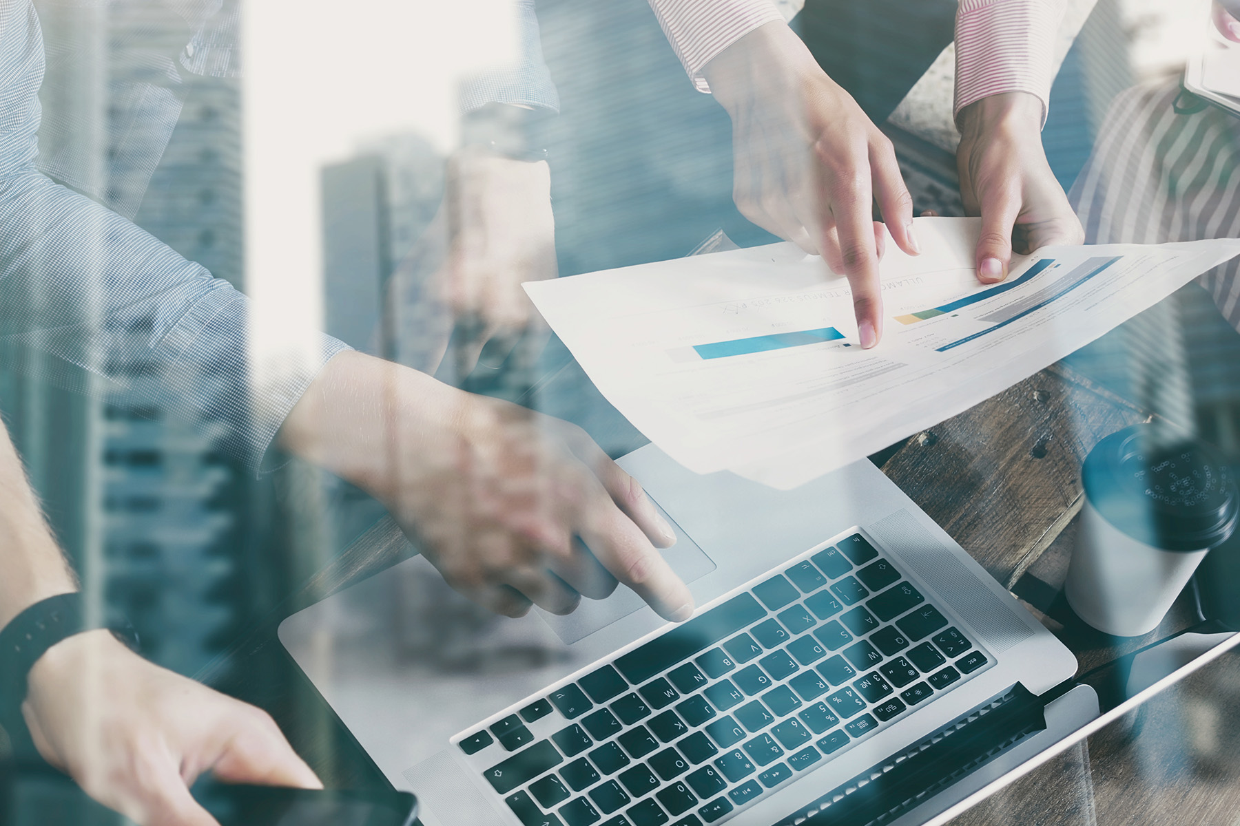 Two professionals reviewing data charts and graphs over a laptop, representing the analysis and optimization of sales processes through CPQ solutions