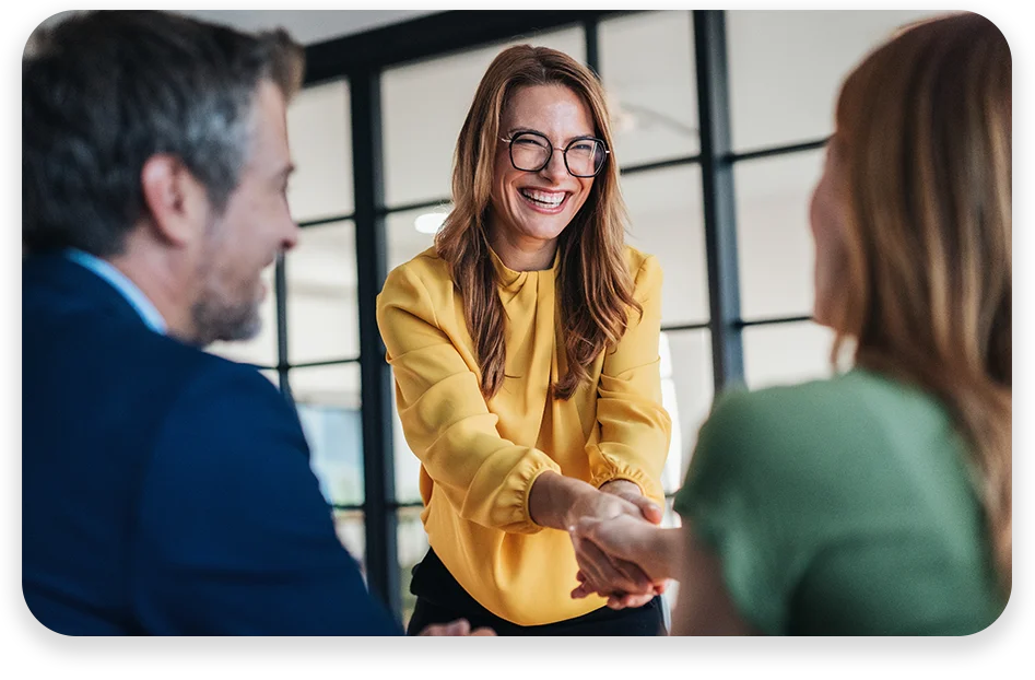 Business meeting with partners and clients, smiling and shaking hands.