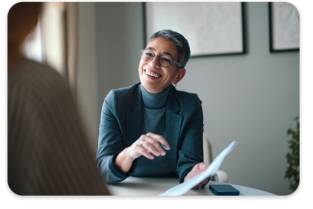 CPQ-Admin-Center-Why-it-Matters Smiling business woman pointing to a document in an office.