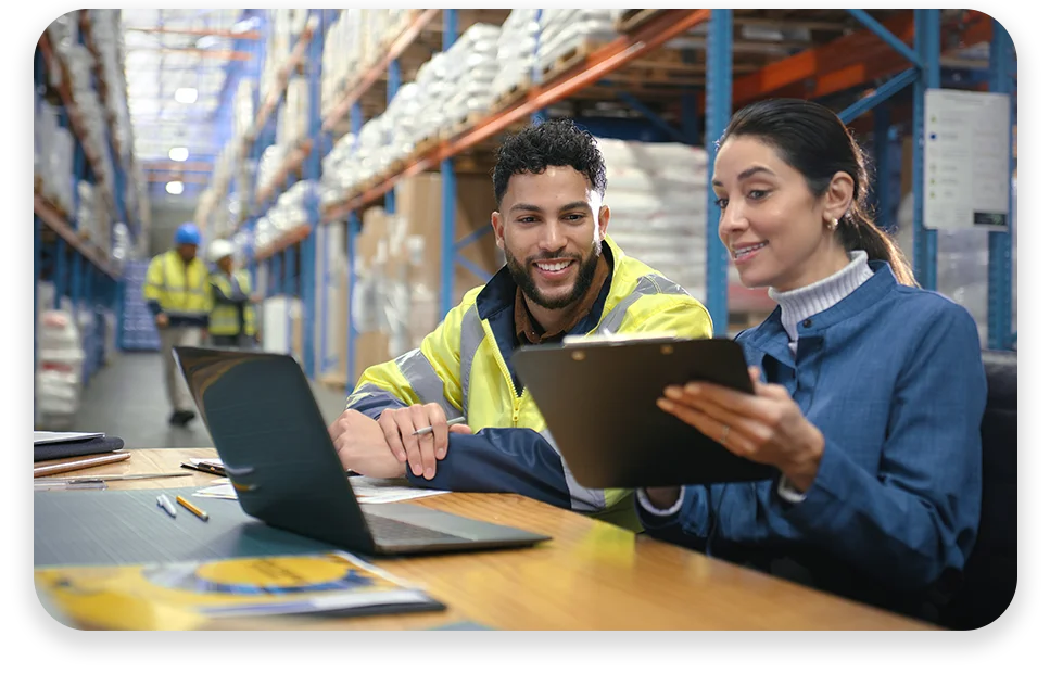CPQ4 Warehouse or manufacturing workers looking at a laptop and tablet device.