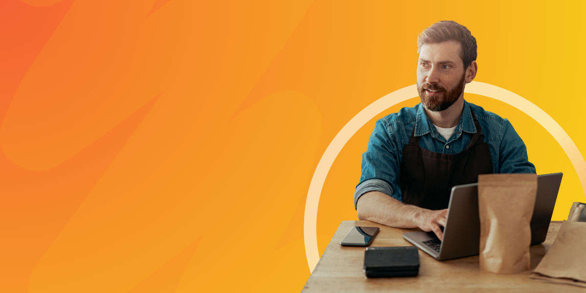 Lean-manufacturing-guide-A-modern-manufacturing-plant-with-workers-and-machinery-highlighting-physical-waste-like-cardboard-boxes-and-plastic-packaging-as-well-as-inefficien A man in a working apron using a laptop.