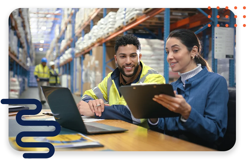 Warehouse or manufacturing workers looking at a laptop and tablet device.