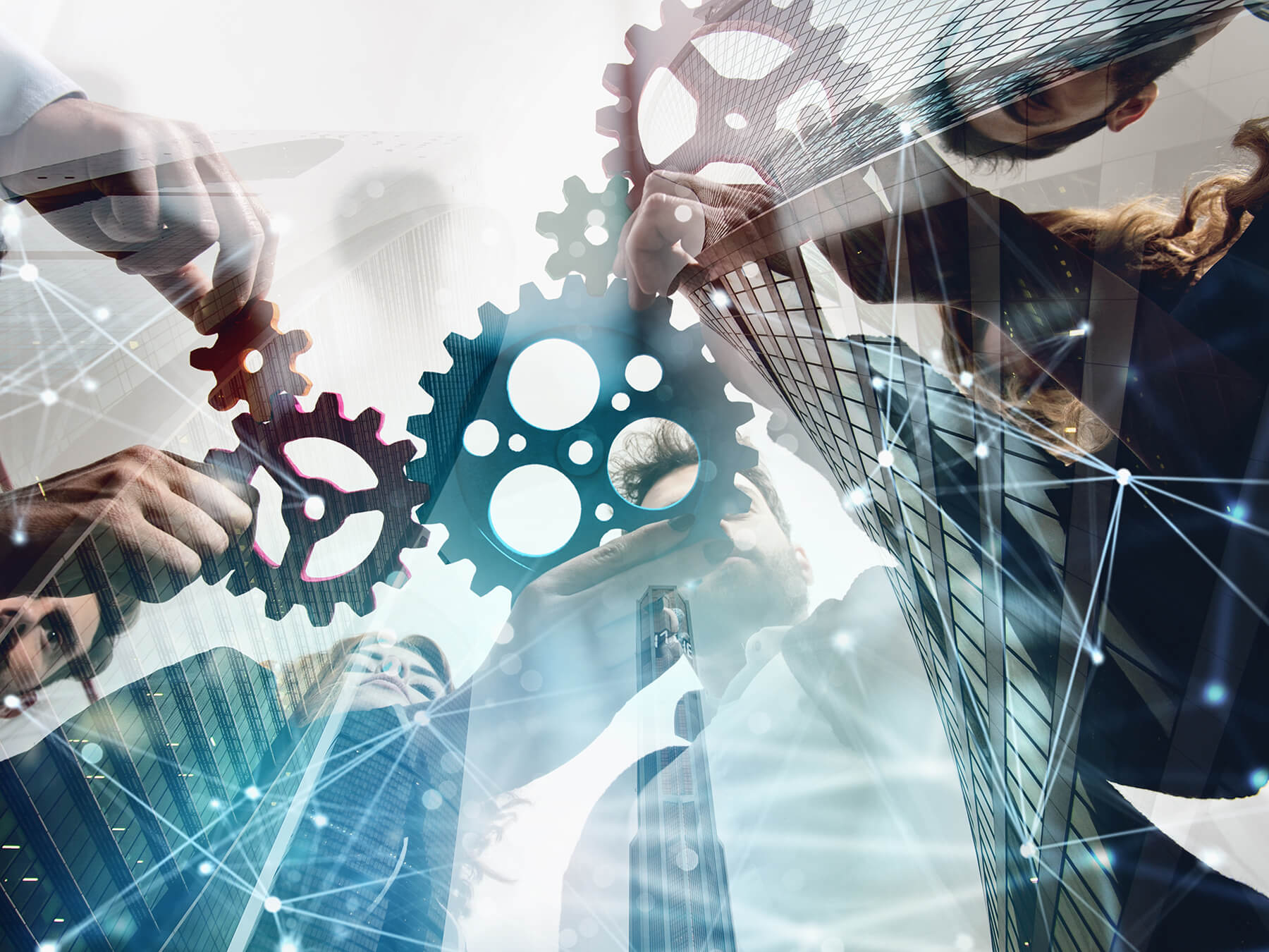The-Challenges-of-Complexity_Header An abstract image with a city skyline superimposed over a group of people holding gears.