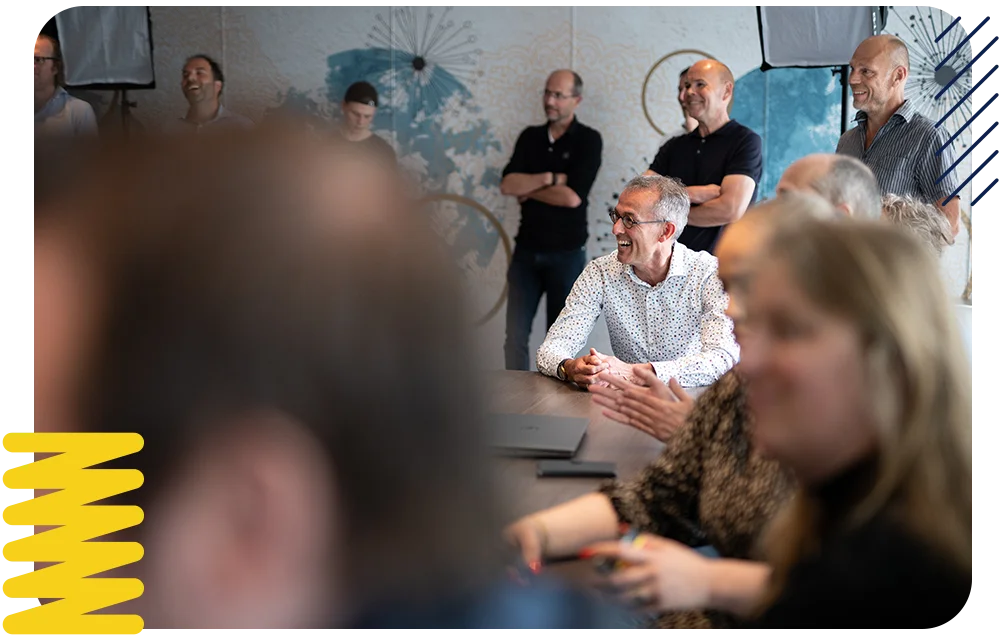 Experlogix employees meeting together in a conference room, smiling.