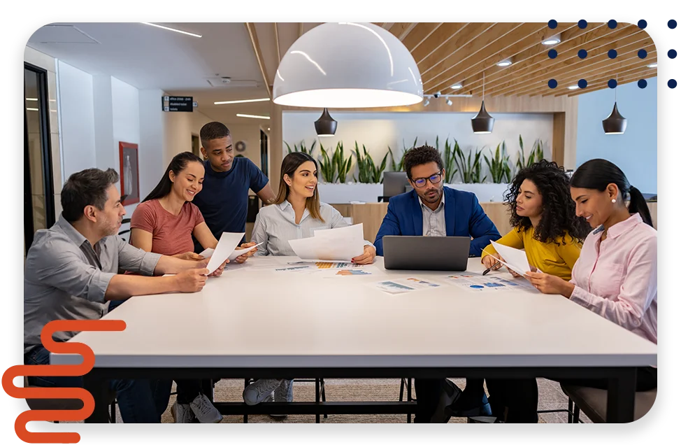 An office with cool lighting and business coworkers sitting at a table in a meeting.